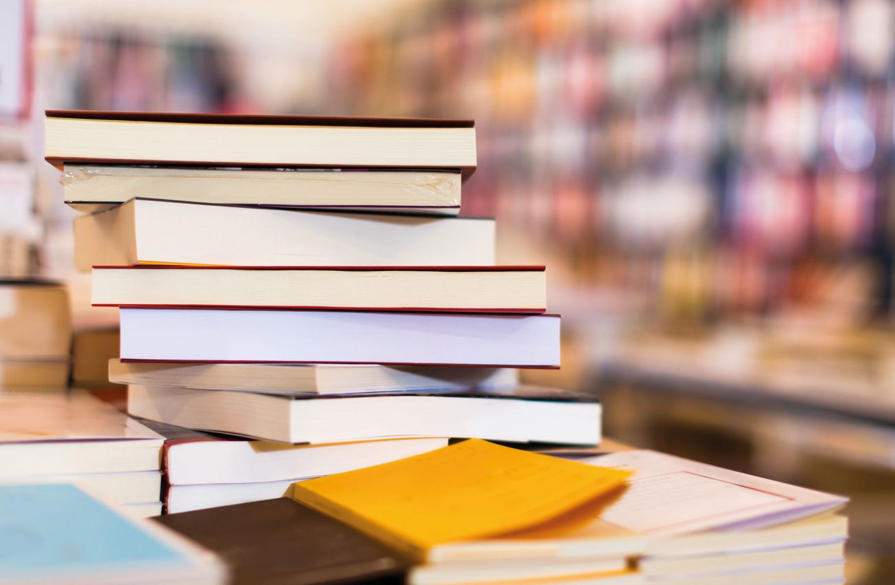 different books lying on table in library