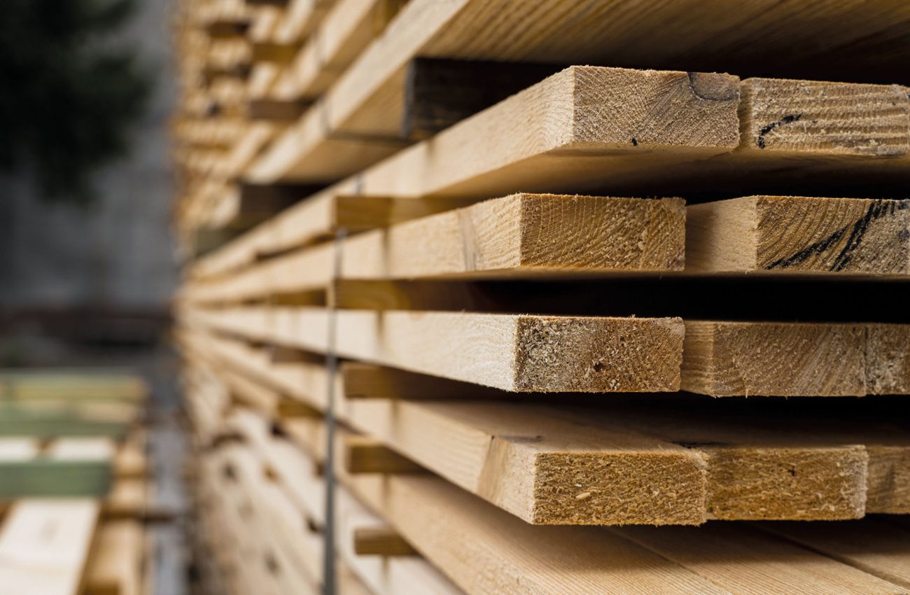 Piles of wooden boards in the sawmill, planking. Warehouse for sawing boards on a sawmill outdoors. Wood timber stack of wooden blanks construction material. Industry.